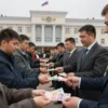 A government building in Astrakhan with Russian flags and officials distributing cash to citizens, showing a crowd receiving money from officials, modern Russian government architecture, people in business attire, subtle financial documents visible, no text or numbers on money