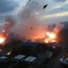 A dramatic scene of explosions in Kyiv, with bright flashes, smoke, and debris in the air, showing a cityscape under attack with buildings, streets, and vehicles affected by the blasts, capturing the chaos and intensity of the moment