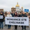 A group of people in a city square, holding signs and banners with messages about financial responsibility and avoiding loans. The scene is set in Chelyabinsk, with recognizable local landmarks in the background. The people are diverse in age and gender, showing a community effort. The atmosphere is peaceful and determined, with a sense of unity and shared purpose.