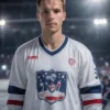 A professional ice hockey player in a modern uniform of Admiral Vladivostok hockey team, wearing a navy and white jersey with the Admiral logo, holding a hockey stick, standing on an ice rink with stadium lights and crowd blurred in background, realistic portrait style