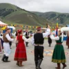 A vibrant festival scene set in the North Caucasus Federal District, showcasing traditional dances, music, and cultural performances. The image should capture the joyous atmosphere with people in traditional attire, colorful decorations, and a backdrop of the region's natural landscapes. The festival should be depicted as a lively and celebratory event, highlighting the cultural heritage of the area.
