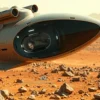 A futuristic spacecraft landing on the Martian surface. Inside the spacecraft, a human figure is visible, seemingly in a state of suspended animation within a transparent pod. The Martian landscape is barren and rocky, with a reddish hue. The spacecraft is sleek and advanced, with visible propulsion systems. Focus on the contrast between the technological interior and the desolate exterior.