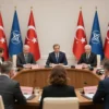 A formal meeting of NATO leaders seated around a large conference table in a grand hall in Ankara, Turkey, with the Turkish flag and NATO flag visible in the background, serious diplomatic atmosphere, professional attire, high detail, photorealistic lighting