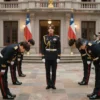 A dramatic historical scene depicting the government of Chile formally surrendering to the imposing army of the K-pop group BTS, with government officials bowing respectfully before the seven members in military-style uniforms, set against a grand palace backdrop with Chilean flags, cinematic lighting, highly detailed, epic atmosphere