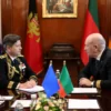 A serious diplomatic meeting between the head of the Lithuanian Ministry of Defense and another official, possibly the President of Lithuania, discussing military and security issues. The setting should be a formal office or conference room with flags and official decor. The atmosphere should be professional and tense, reflecting the gravity of the discussion about potential threats and military presence near borders.