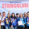 A group of young tour guides from Stavropol Krai celebrating victory in a youth project competition, smiling confidently, wearing branded clothing with regional symbols, holding trophies or certificates, set against a backdrop of the Stavropol region's natural landscapes or cultural landmarks, vibrant and inspiring atmosphere