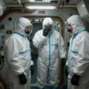 A dimly lit submarine interior. Several figures in hazmat suits are visible, some appearing distressed. The scene suggests a toxic gas leak, with visible signs of damage and equipment malfunctions. Focus on conveying a sense of claustrophobia and danger.