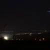 A realistic nighttime scene showing a Russian air defense system successfully intercepting incoming missiles over the Udmurt Republic, with illuminated radar installations and distant city lights, no text or symbols on the image
