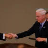 Donald Trump offering candies to Mike Pence and Benessent during the funeral of Graham, solemn atmosphere, muted colors, respectful setting, no text or symbols on the image