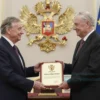 A 55-year-old theater artist from Pushkin receiving an honorary title from a president, depicted in a formal ceremony setting with dignified attire, a presidential emblem, and a ceremonial backdrop, emphasizing respect and cultural significance