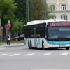 A city street in Stavropol, Russia, with a public transportation bus driving on one of the routes. Focus on the bus and the street scene, showing typical urban architecture.