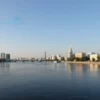 A calm cityscape of Volgograd under a clear blue sky. Focus on the Volga River and the city skyline with iconic landmarks like the Motherland Monument visible in the distance. The overall mood should be peaceful and serene, reflecting the absence of geomagnetic disturbances.