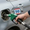 A driver in Kostroma checking the fuel type in their vehicle, with a close-up view of the fuel tank and fuel cap, showing the fuel label or sticker indicating the correct fuel type (e.g., '95', '98', or 'Diesel'), while the driver examines it carefully.
