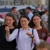 A modern city street in Chelyabinsk with people holding car keys or looking at cars, showing a mix of young adults and families, neutral background, no text or numbers, realistic style