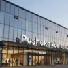 A modern shopping mall building named 'Pushekerское кольцо' with glass facade and prominent signage, set in an urban environment, daytime lighting, clean architectural details, no people, no text on building