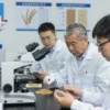 A group of scientists in a laboratory setting in Chelyabinsk, Russia, examining grain samples under microscopes and discussing their adaptation to harsh environmental conditions, with detailed scientific equipment and charts showing data on grain resilience