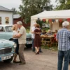 A retro-themed outdoor gathering for residents over 50 in Kostroma, featuring vintage cars, classic music, and nostalgic decorations like old posters and retro fashion. Include people dancing, chatting, and enjoying food and drinks in a festive atmosphere.