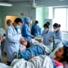 A group of medical professionals providing aid to patients in a hospital setting. The scene should depict a busy medical facility with doctors, nurses, and patients. The focus should be on the medical staff attending to the patients, showing a sense of urgency and care. The environment should include medical equipment, beds, and other hospital furnishings.