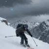 A dramatic winter scene showing a lone skier struggling against fierce winds and heavy snowfall on a snowy mountain slope, with blurred motion to emphasize the intensity of the blizzard conditions, dark stormy sky, and a sense of isolation and hardship