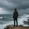 A person standing on a cliff overlooking a stormy sea, with dark clouds and crashing waves, symbolizing the struggle against despair and inner strength