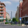 A vibrant urban street transformation project in Yaroslavl, showcasing a modernized street named Andropova with renovated buildings, new pavement, green spaces, and contemporary architectural elements, captured in a realistic style